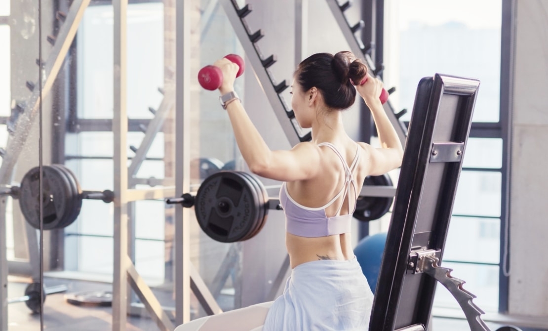 軽めのダンベルを持って腕を鍛える女性の様子。スタジオ内のフリースペースで自由にトレーニングできます！